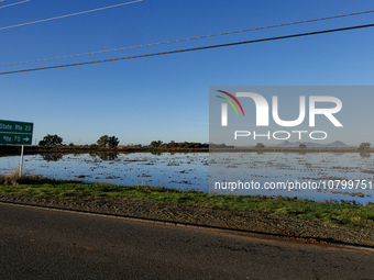 The sun rises over flooded California rice fields, during a storm break brought on by an atmospheric river near Marysville, Calif., on Sunda...