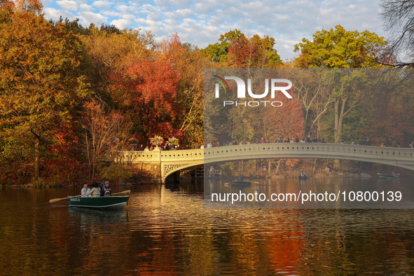 People take photos on the Oak Bridge in Central Park while enjoying the fall weather in New York City, New York , Monday, Nov. 6, 2023.  