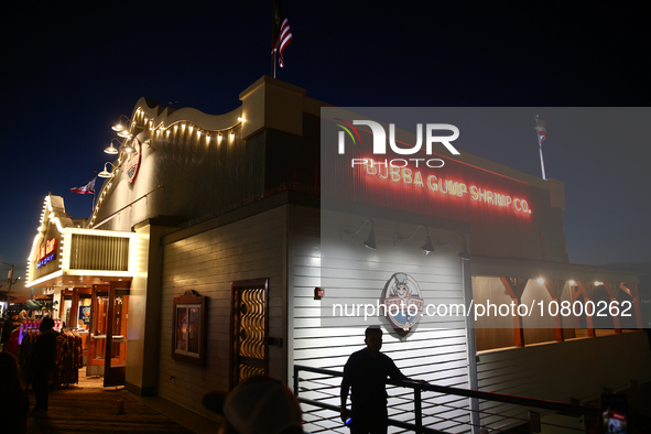 People are seen near Bubba Gump Shrimp Co. restaurant in Santa Monica, United States on November 12, 2023. 