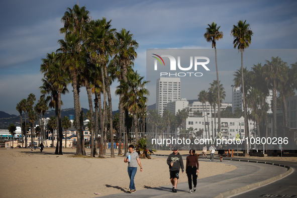 People walk the beach in Santa Monica, United States on November 13, 2023. 