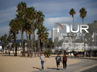 People walk the beach in Santa Monica, United States on November 13, 2023. (