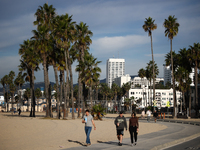 People walk the beach in Santa Monica, United States on November 13, 2023. (