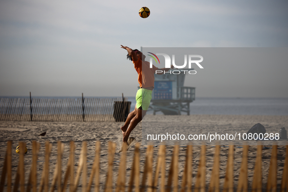 A person plays volleyball on the beach in Santa Monica, United States on November 13, 2023. 