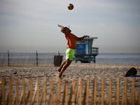 A person plays volleyball on the beach in Santa Monica, United States on November 13, 2023. (