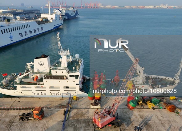 YANTAI, CHINA - NOVEMBER 21, 2023 - At Longkou Port in Shandong province, a crane loads a navigation mark onto the ''Haixun 153'' navigation...