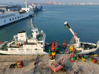 YANTAI, CHINA - NOVEMBER 21, 2023 - At Longkou Port in Shandong province, a crane loads a navigation mark onto the ''Haixun 153'' navigation...