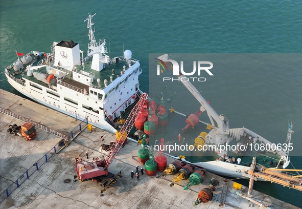 YANTAI, CHINA - NOVEMBER 21, 2023 - At Longkou Port in Shandong province, a crane loads a navigation mark onto the ''Haixun 153'' navigation...