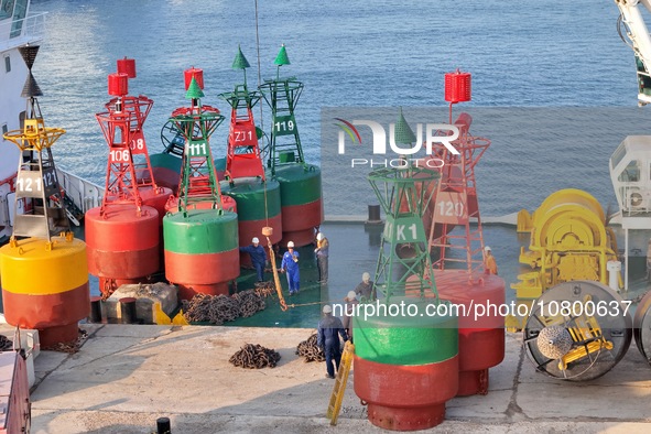 YANTAI, CHINA - NOVEMBER 21, 2023 - At Longkou Port in Shandong province, a crane loads a navigation mark onto the ''Haixun 153'' navigation...