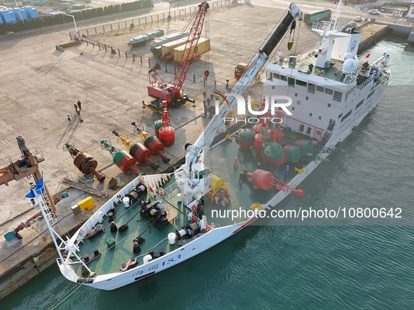 YANTAI, CHINA - NOVEMBER 21, 2023 - At Longkou Port in Shandong province, a crane loads a navigation mark onto the ''Haixun 153'' navigation...