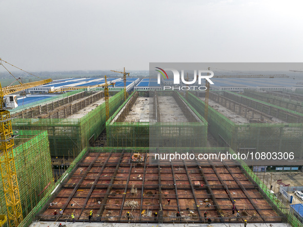 Workers are working at the construction site of a comprehensive utilization base for automobile recycling in Lianyungang, East China's Jiang...