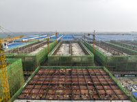 Workers are working at the construction site of a comprehensive utilization base for automobile recycling in Lianyungang, East China's Jiang...