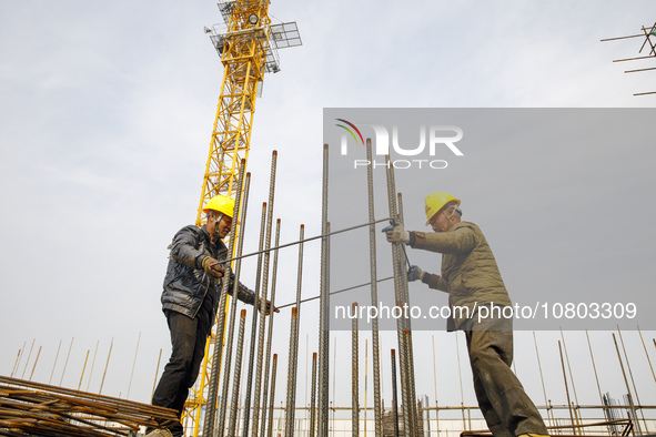 Workers are working at the construction site of a comprehensive utilization base for automobile recycling in Lianyungang, East China's Jiang...