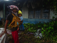 Nurhalimah Br Sembiring Milala, 33, is seen working with her two-year-old child, Gloria Br Ginting, on her plantation in Gamber Village, Sim...