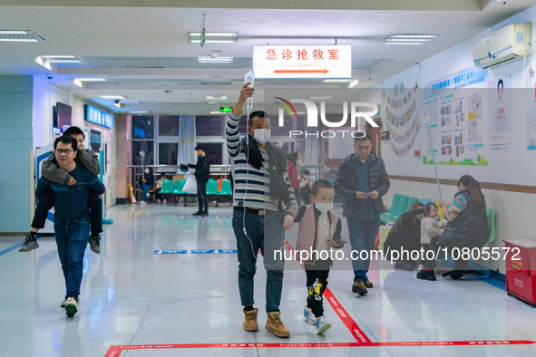 Parents with children who are suffering from respiratory diseases are lining up at a children's hospital in Chongqing, China, on November 23...