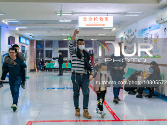 Parents with children who are suffering from respiratory diseases are lining up at a children's hospital in Chongqing, China, on November 23...