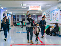 Parents with children who are suffering from respiratory diseases are lining up at a children's hospital in Chongqing, China, on November 23...