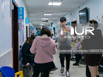 Parents with children who are suffering from respiratory diseases are lining up at a children's hospital in Chongqing, China, on November 23...