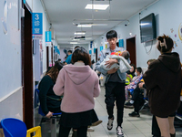 Parents with children who are suffering from respiratory diseases are lining up at a children's hospital in Chongqing, China, on November 23...