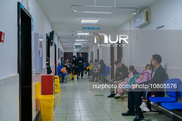 Parents with children who are suffering from respiratory diseases are lining up at a children's hospital in Chongqing, China, on November 23...