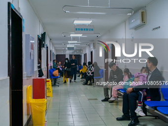 Parents with children who are suffering from respiratory diseases are lining up at a children's hospital in Chongqing, China, on November 23...