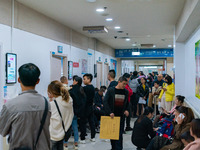 Parents with children who are suffering from respiratory diseases are lining up at a children's hospital in Chongqing, China, on November 23...