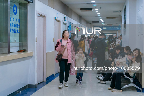 Parents with children who are suffering from respiratory diseases are lining up at a children's hospital in Chongqing, China, on November 23...