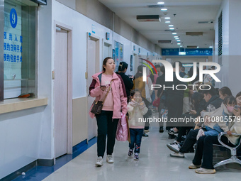 Parents with children who are suffering from respiratory diseases are lining up at a children's hospital in Chongqing, China, on November 23...