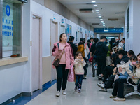 Parents with children who are suffering from respiratory diseases are lining up at a children's hospital in Chongqing, China, on November 23...