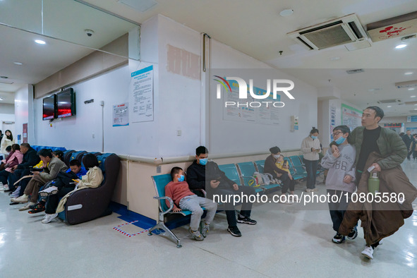 Parents with children who are suffering from respiratory diseases are lining up at a children's hospital in Chongqing, China, on November 23...