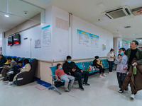 Parents with children who are suffering from respiratory diseases are lining up at a children's hospital in Chongqing, China, on November 23...