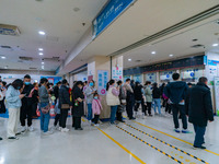 Parents with children who are suffering from respiratory diseases are lining up at a children's hospital in Chongqing, China, on November 23...