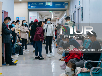 Parents with children who are suffering from respiratory diseases are lining up at a children's hospital in Chongqing, China, on November 23...