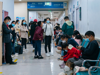 Parents with children who are suffering from respiratory diseases are lining up at a children's hospital in Chongqing, China, on November 23...