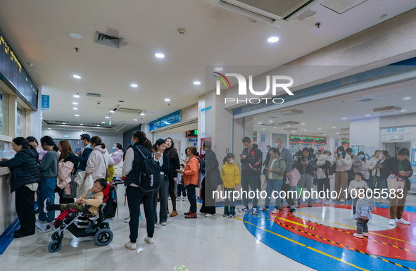 Parents with children who are suffering from respiratory diseases are lining up at a children's hospital in Chongqing, China, on November 23...