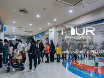 Parents with children who are suffering from respiratory diseases are lining up at a children's hospital in Chongqing, China, on November 23...