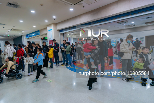 Parents with children who are suffering from respiratory diseases are lining up at a children's hospital in Chongqing, China, on November 23...