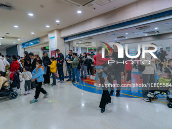 Parents with children who are suffering from respiratory diseases are lining up at a children's hospital in Chongqing, China, on November 23...