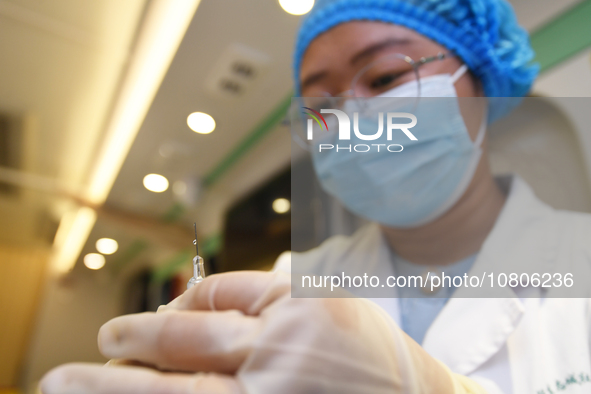 A health care worker is checking a student before administering a flu shot in Guiyang, Guizhou Province, China, on November 24, 2023. 