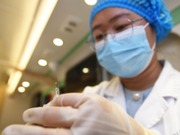 A health care worker is checking a student before administering a flu shot in Guiyang, Guizhou Province, China, on November 24, 2023. (