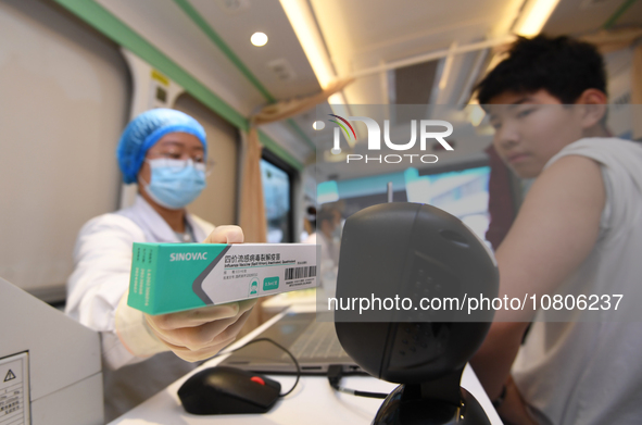 A medical worker is inoculating students against influenza on a mobile vaccination vehicle in Guiyang, Guizhou province, China, on November...