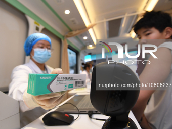 A medical worker is inoculating students against influenza on a mobile vaccination vehicle in Guiyang, Guizhou province, China, on November...