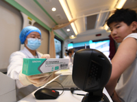 A medical worker is inoculating students against influenza on a mobile vaccination vehicle in Guiyang, Guizhou province, China, on November...