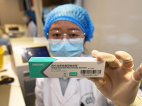 A health care worker is displaying a flu vaccine at a community health service center in Guiyang, Guizhou province, China, on November 24, 2...