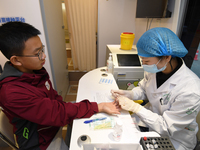 A medical worker is inoculating students against influenza on a mobile vaccination vehicle in Guiyang, Guizhou province, China, on November...