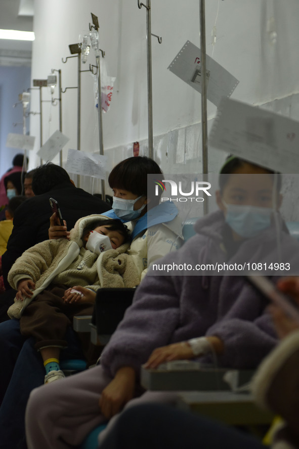 Sick children, accompanied by their parents, are receiving infusion treatment at the Department of Pediatrics of the People's Hospital in Fu...