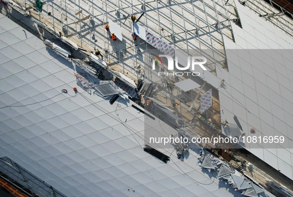 Workers are installing the facade of the experimental building for Zhejiang University's High gravity centrifugal simulation and experimenta...