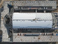 Workers are installing the facade of the experimental building for Zhejiang University's High gravity centrifugal simulation and experimenta...