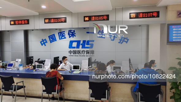 A community service center for China Medical Insurance (Medical security) is operating with an office window and self-service area in Shangh...