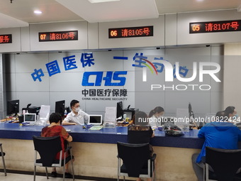 A community service center for China Medical Insurance (Medical security) is operating with an office window and self-service area in Shangh...