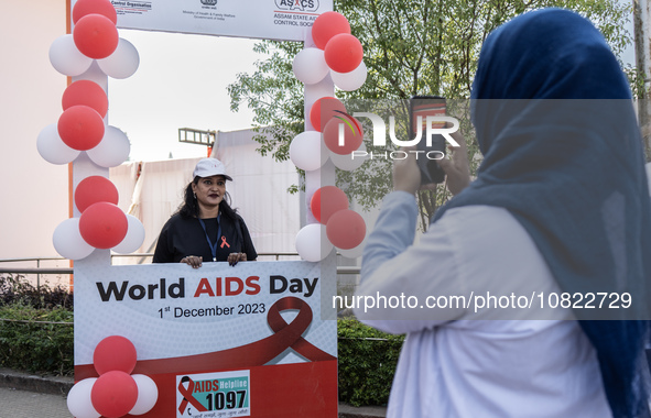 A woman is posing for a photograph in a booth during an event to mark World AIDS Day in Guwahati, Assam, India, on December 1, 2023. 